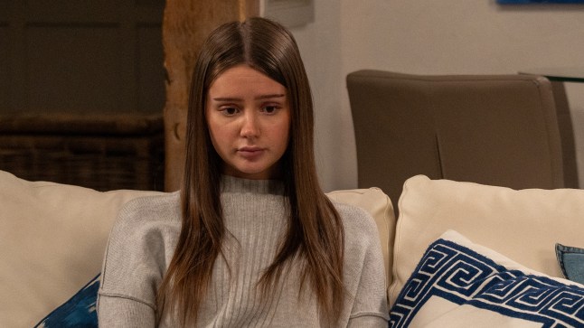 Sarah Sugden looking heartbroken on the sofa in Emmerdale.