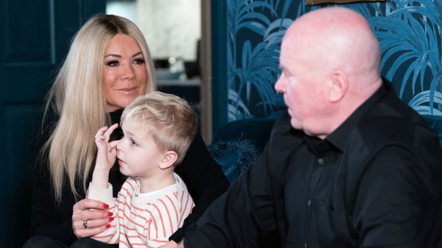 Sharon and Phil talk whilst Albie sits between them in EastEnders