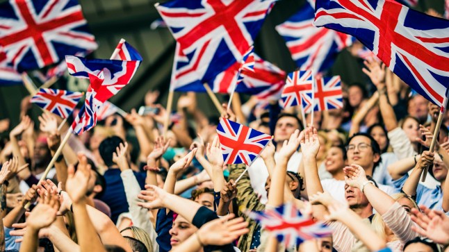 Large group of people with several Union Jack flags flying