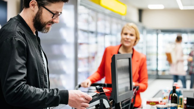 Mature Man Paying For Groceries With Contactless Payment
