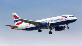 A British Airways Airbus A320 aeroplane flying across a blue sky.