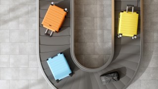 Four suitcases moving on an airport conveyor belt.