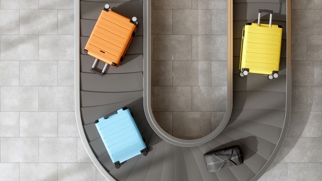 Four suitcases moving on an airport conveyor belt.