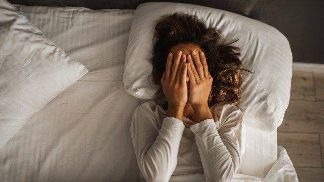 Woman in depression closed face with hands and crying in bed. Melancholy mood, mental health. Life problems