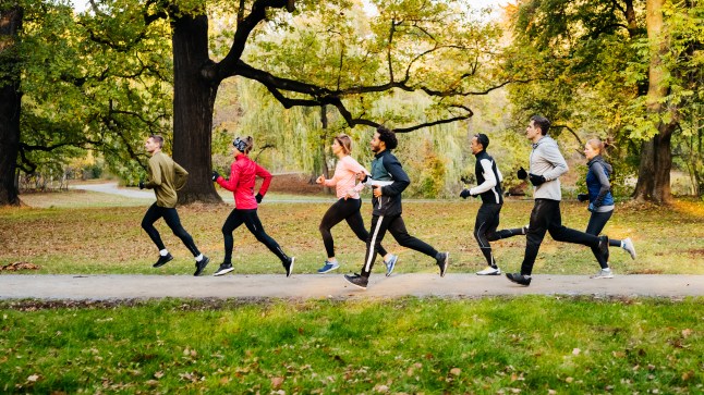 A group of runners racing through the park