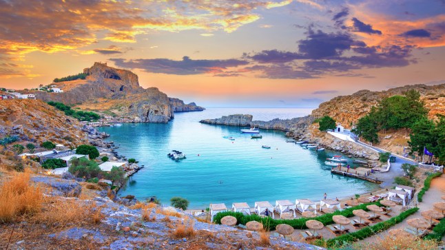 Panoramic view of St. Paul bay with acropolis of Lindos in the background in Rhodes, Greece.