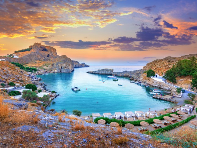 Panoramic view of St. Paul bay with acropolis of Lindos in the background in Rhodes, Greece.
