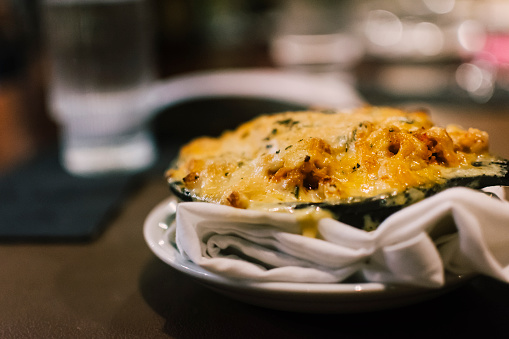 Alligator Chorizo Mac and Cheese meal, on a bar counter with a napkin