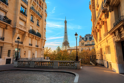 A view of the Eiffel Tower from between two tall buildings in Paris, France.