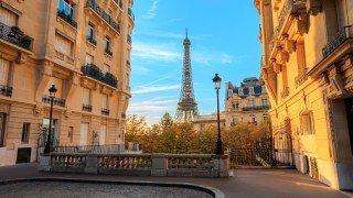 A view of the Eiffel Tower from between two tall buildings in Paris, France.
