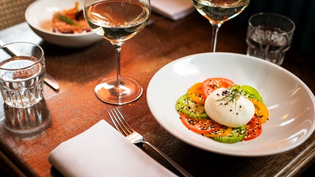A starter of Burrata served with colourful tomatoes in a restaurant in London