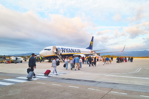 Travelers Boarding Ryanair Plane at Airport Runway during Sunset
