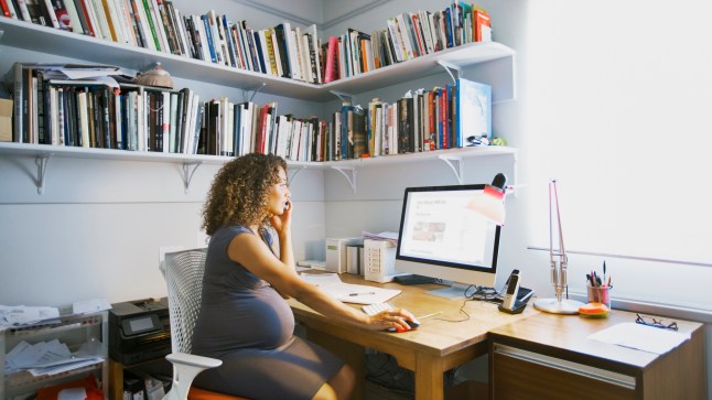 Pregnant lady works from her home office.