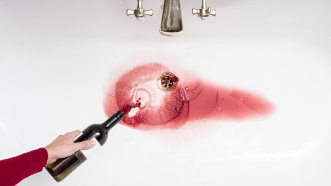 Pouring away wine in an act of giving up alcohol