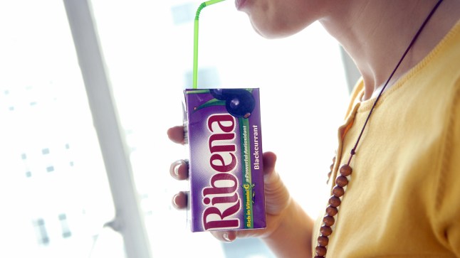 A woman sips a Ribena drink in London