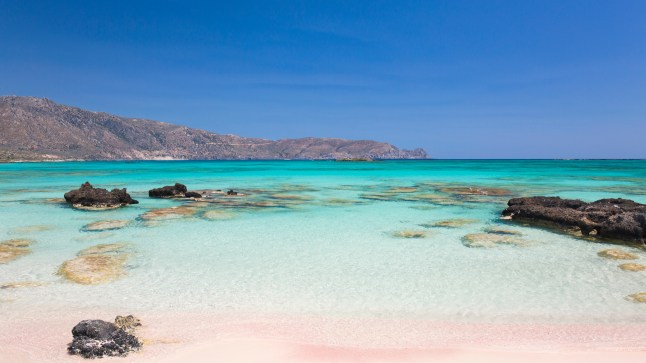 View across the clear turquoise waters of Vroulia Bay in Crete, Greece.