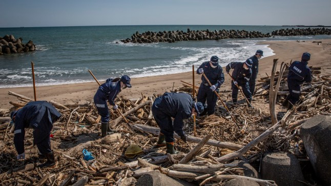 NAMIE, JAPAN - MARCH 11: Police officers search for the remains of people who went missing after the 2011 Tohoku earthquake and tsunami on March 11, 2021 in Namie, Japan. Japan will today observe the 10th anniversary of the 2011 Tohoku earthquake, tsunami and triple nuclear meltdown in which almost 16,000 were killed and hundreds of thousands made homeless. The magnitude 9.0 earthquake was one of the most powerful ever recorded. It triggered tsunami waves up to 40.5 meters high that travelled at 700km/h and surged up to 10km inland destroying entire towns. It moved Japan???s main island of Honshu 2.4m east, shifted the Earth on its axis by estimates of between 10cm and 25cm and increased the planet???s rotational speed by 1.8 microseconds per day. (Photo by Yuichi Yamazaki/Getty Images)