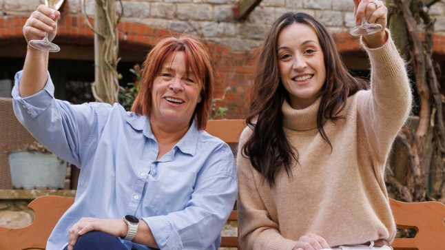 Jo Booth and Hannah Symes toast with a glass of champagne.