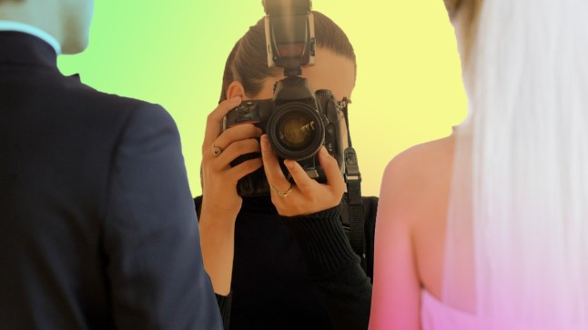 A photographer snapping a picture of a bride and groom
