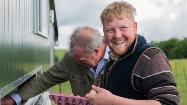Kaleb Cooper smiling as he works on Diddly Squat farm with Jeremy Clarkson