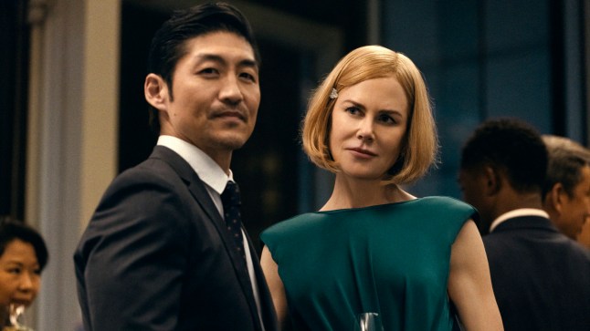 Nicole Kidman as Margaret standing next to her husband Brian Tee as Clarke at a party in Amazon Prime show Expats