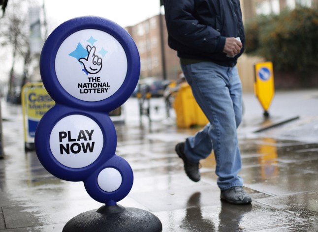 National Lottery sign with man walking past.