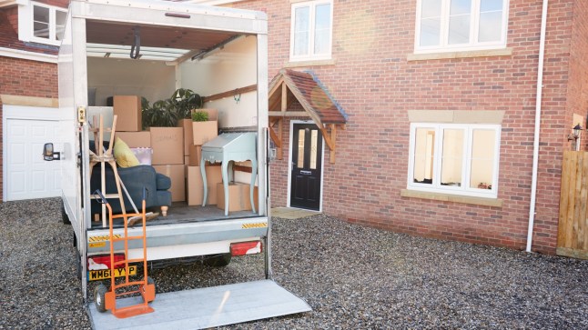 Removal Truck Waiting To Be Unloaded Outside New Home On Moving Day