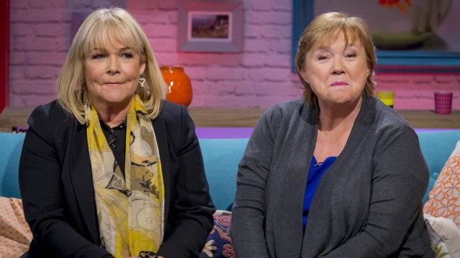 Linda Robson and Pauline Quirke sitting on a TV set sofa together in 2015