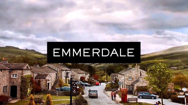 Emmerdale logo over the cloudy village.