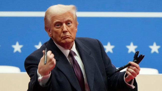 FILE - President Donald Trump throws pens used to sign executive orders to the crowd during an indoor Presidential Inauguration parade event in Washington, Monday, Jan. 20, 2025. (AP Photo/Matt Rourke, File)