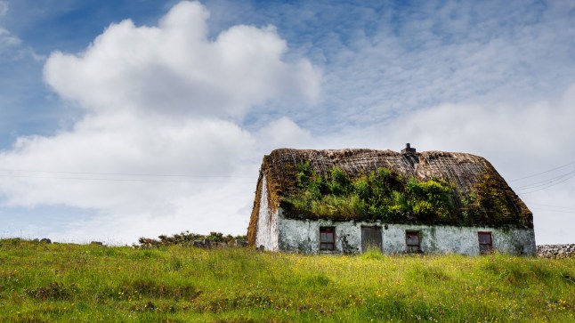 Old country house in a field on a warm sunny day, blue sky. Inishmore, Aran Islands, County Galway, Ireland. Irish landscape; Shutterstock ID 1994320256; purchase_order: -; job: -; client: -; other: -