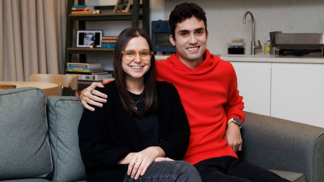 Pedro and Fiona on the living room sofa inside their flat in East London.