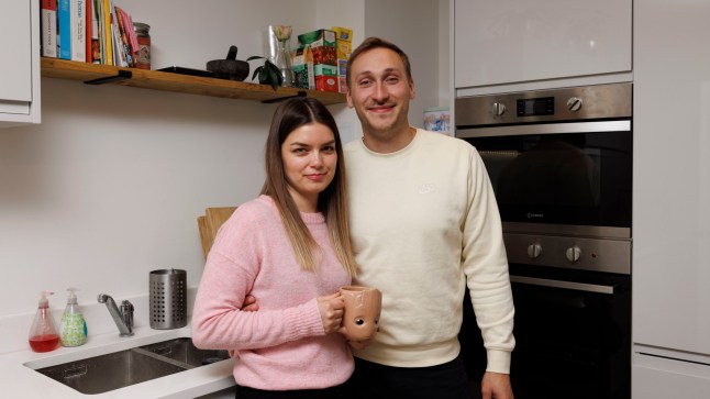 Homeowners Ben and Dorottya smile in their kitchen.