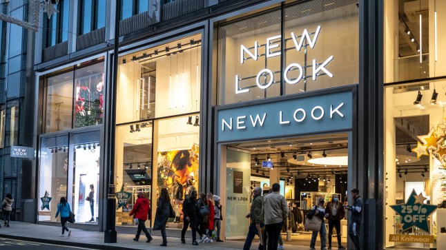 London, UK - October 29 2020 New Look clothes modern city centre store shop with brand logo and sign illuminated at night busy with tourists and shoppers