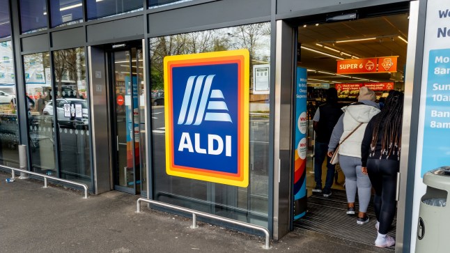 London. UK- 05.01.2023. The entrance and exit of a branch of Aldi grocery supermarket with the company name sign and logo in the middle.