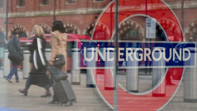 Underground sign with people walking.