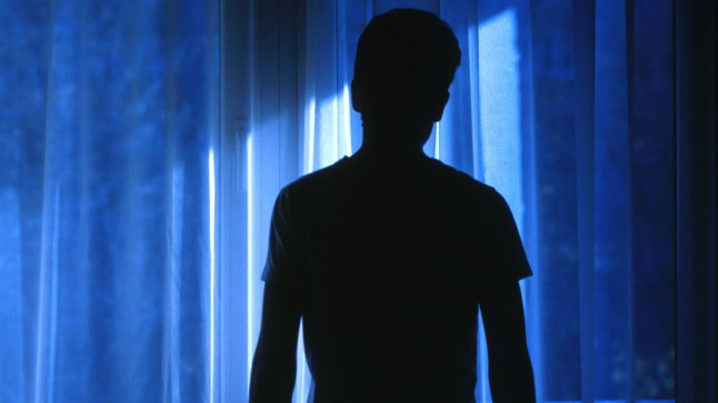 Man standing silhouette in room.