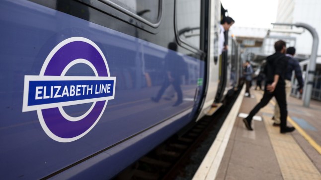 People disembarking the Elizabeth line train at Ealing Broadway station.