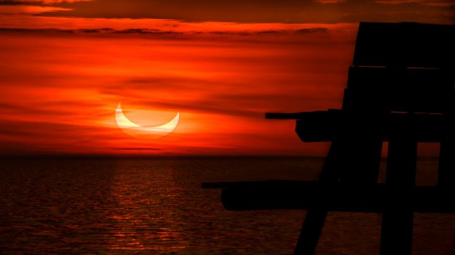 sunrise over the sea during a solar eclipse on June 10, 2021, Cedar Beach, Mt Sinai, New York.; Shutterstock ID 2008694387; purchase_order: -; job: -; client: -; other: -