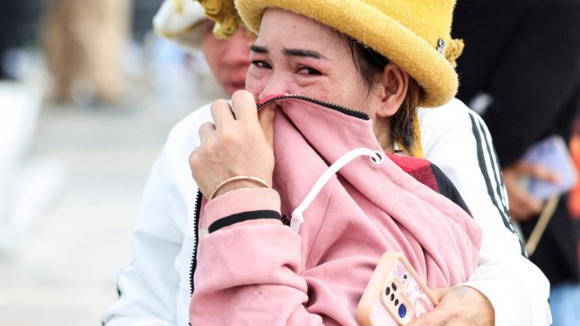 Den San, 33, a Cambodian migrant worker in Thailand for 18 years, reacts as she waits for an update on her brother, Soeurn Saan, 38, and his wife, who were working at the building at the time it collapsed following a strong earthquake, in Bangkok, Thailand, March 29, 2025. REUTERS/Chalinee Thirasupa TPX IMAGES OF THE DAY