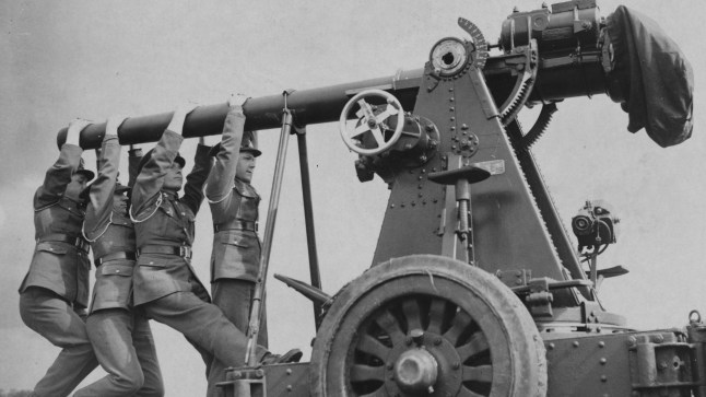Soldiers hang onto the barrel of a 3" anti-aircraft gun to balance it during its transportation over rough ground. | Location: Shoeburyness, England, UK. (Photo by ?? Hulton-Deutsch Collection/CORBIS/Corbis via Getty Images)