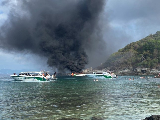 Dozens of tourists swam for their lives to escape a burning speedboat off the coast of Thailand this morning. The 33 holidaymakers and four Thai crew were sailing on the vessel, Tana Marine 555, from Phuket to Koh Mai Thon when it caught fire 50ft from the shore. They jumped overboard to escape the roaring flames and were rescued by a passing boat. Footage shows black smoke plumes billowing from the speedboat lodged between rocks as it was engulfed in flames. Nachapong Pranit, director of the Phuket Marine Office, said authorities deployed a rescue team after receiving a report at 9:20 am. Emergency responders arrived and found the passengers watching the wreckage burn from a distance. All 37 onboard the boat were taken to a hospital for treatment in Phuket. PACKAGE: Video, pictures, text