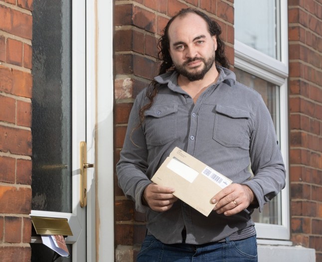 Nathan stood with empty envelope by his front door.