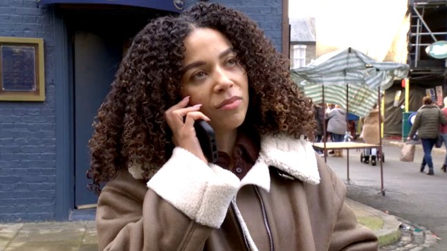 Leonie Elliott as journalist Charlotte on the phone outside the club in Eastenders