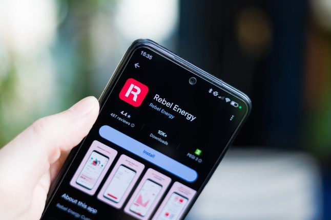 Norwich, Norfolk, UK - February 25th 2025 A close-up of a person's hand holding a smartphone displaying Rebel Energy app; Shutterstock ID 2596968025; purchase_order: -; job: -; client: -; other: -